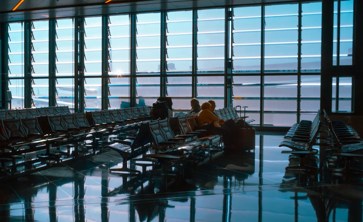 Travelers waiting in a bright international airport terminal
