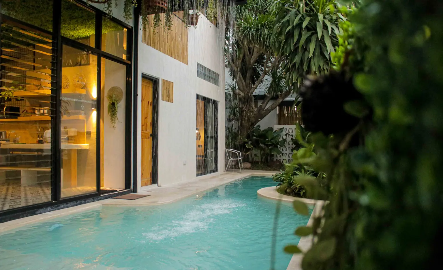 A private villa pool surrounded by tropical plants in Pampanga